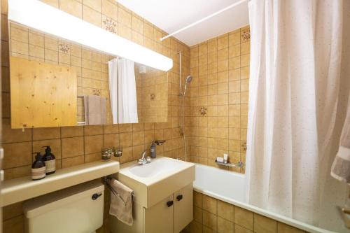 La salle de bains est pourvue d'un lavabo, d'un miroir et d'une baignoire. dans l'établissement Chasa Trais Fluors, à Scuol