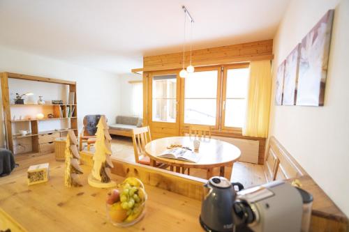 a living room with a table and a dining room at Chasa Trais Fluors in Scuol