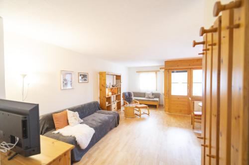 a living room with a couch and a tv at Chasa Trais Fluors in Scuol