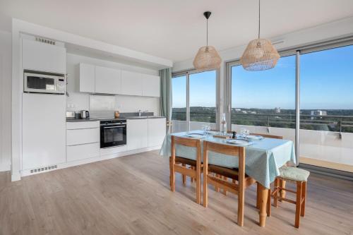 une cuisine et une salle à manger avec une table et des chaises dans l'établissement Vue sur la baie de la Baule !, à La Baule