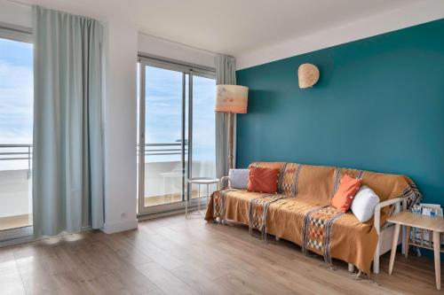 un salon avec un canapé et un mur bleu dans l'établissement Vue sur la baie de la Baule !, à La Baule