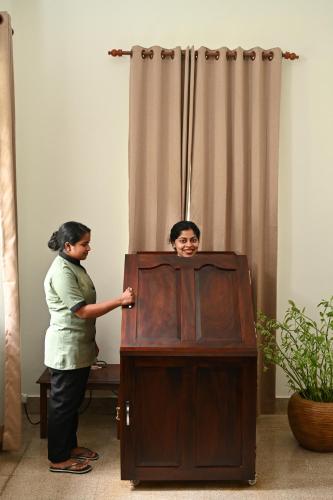 a woman is standing next to a podium at The Sacred Lotus Ayurveda Wellness Retreat in Cochin