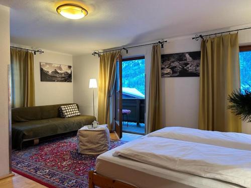 a bedroom with a bed and a couch at Pension Rosenegg in Finkenberg