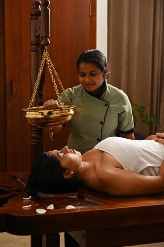 a woman is getting a massage on a bed at The Sacred Lotus Ayurveda Wellness Retreat in Cochin