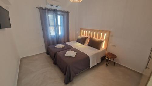 Mykonian Tramonti Villas في مدينة ميكونوس: غرفة نوم عليها سرير وفوط