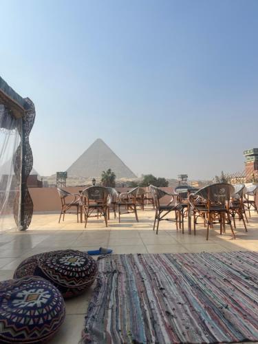a group of chairs and tables with a pyramid in the background at Badr pyramids view in Cairo