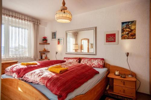 a bedroom with a large bed with a red blanket at Haus Edelweiß in Schlucht