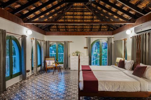 um quarto com uma cama grande e janelas grandes em The Sacred Lotus Ayurveda Wellness Retreat em Cochin