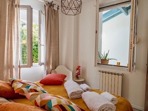 une chambre avec un lit avec des oreillers et une fenêtre dans l'établissement CHALET BTZ, à Biarritz