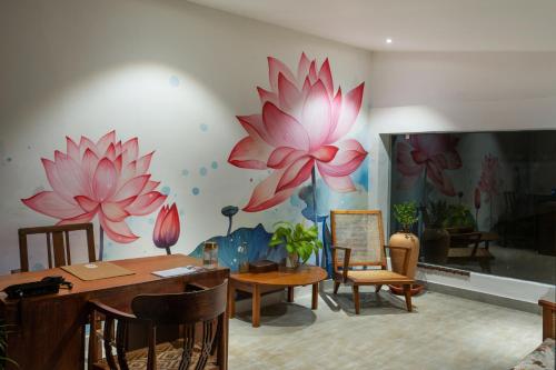 uma sala de jantar com flores pintadas na parede em The Sacred Lotus Ayurveda Wellness Retreat em Cochin
