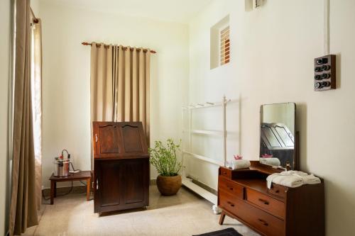 a dressing room with a dresser and a mirror at The Sacred Lotus Ayurveda Wellness Retreat in Cochin