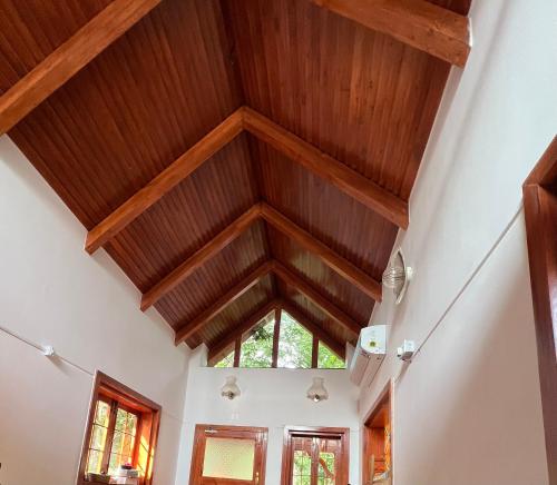 a room with a ceiling with wooden beams at Little Things Earth - Pine villa in Auroville