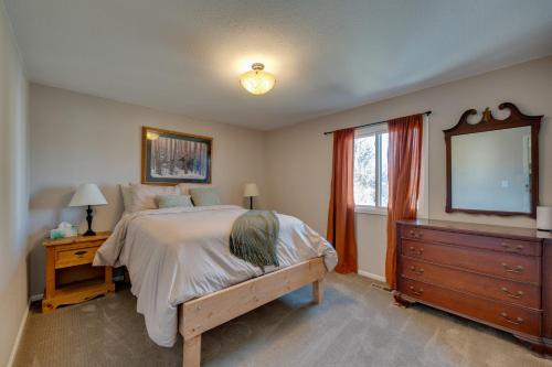 a bedroom with a bed and a dresser and a mirror at Loveland Home with Private Hot Tub and Wood Fireplace! in Loveland
