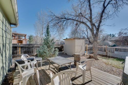 a deck with white chairs and a table and a tree at Loveland Home with Private Hot Tub and Wood Fireplace! in Loveland