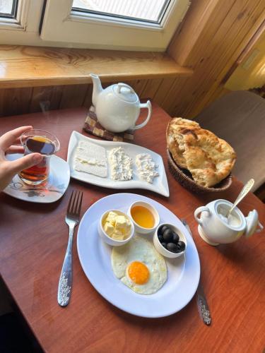 a table with a plate of eggs and coffee and a pie at HOSTEL124 in Baku