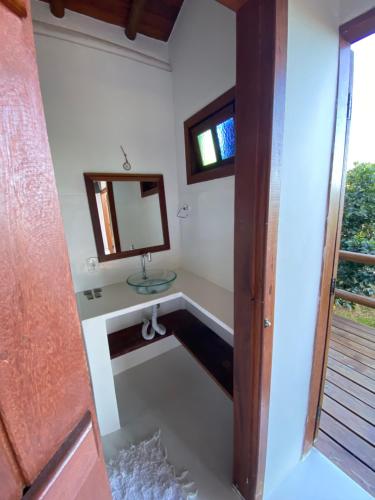 a bathroom with a sink and a mirror at Casa Lua Cheia in Praia do Espelho