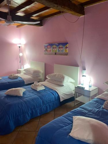 a bedroom with two beds and a pink wall at B&B Happiness in the Country in Brescello