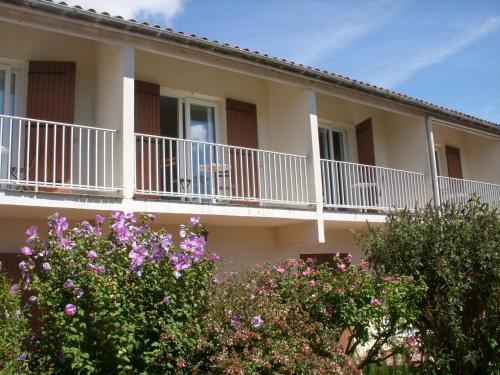 a white and blue house with a balcony at Hotel Les Vieux Acacias in Queyrac