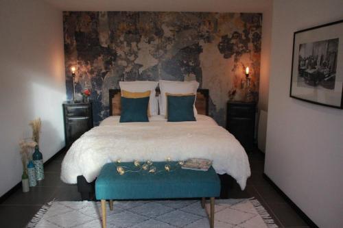a bedroom with a large bed with blue pillows at La Catiniere in Arnage