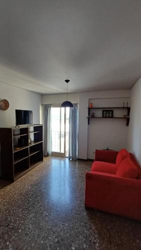 sala de estar con sofá rojo y TV en Departamento en pleno centro en Mendoza
