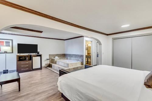 a hotel room with a bed and a bath tub at Park Inn by Radisson, Salt Lake City-Midvale in Midvale