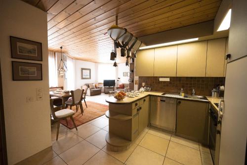a kitchen and living room with a dining room at Chasa Serras - Döpper in Scuol