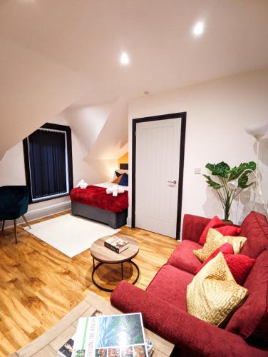 ein Wohnzimmer mit einem roten Sofa und einem Tisch in der Unterkunft A&A Luxury Stay Alice in Sunderland