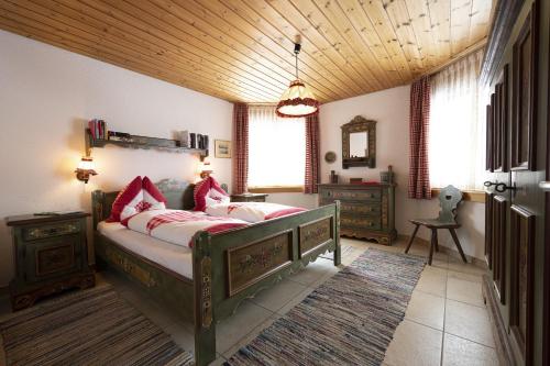 a bedroom with a bed and a wooden ceiling at Chasa Serras - Döpper in Scuol