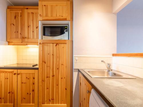uma cozinha com armários de madeira e um lavatório em Appartement Avoriaz, 3 pièces, 6 personnes - FR-1-314-162 em Avoriaz