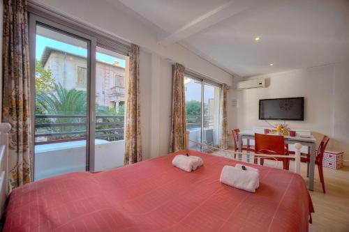 une chambre avec un lit rouge et une grande fenêtre dans l'établissement Studio spacieux 3min plages croisette A0B123, à Cannes
