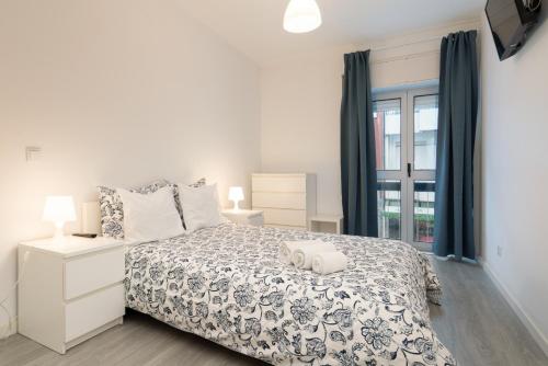 a white bedroom with a bed and a window at Moreira Family in Porto