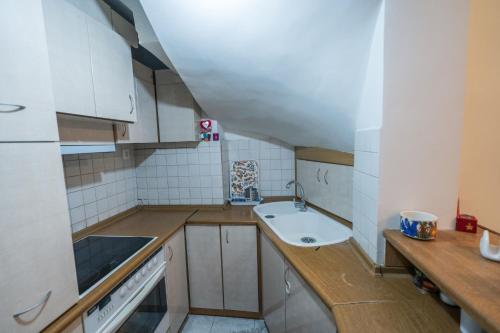 a small kitchen with white cabinets and a sink at Marina Apartment in Piraeus
