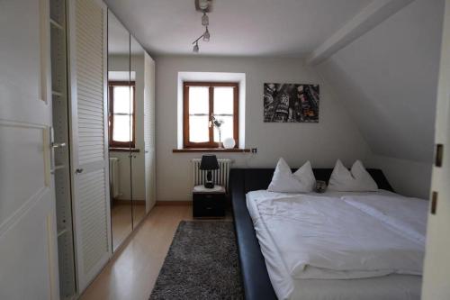 a bedroom with a white bed and a mirror at City- Wohnung in Top Lage in Ingolstadt