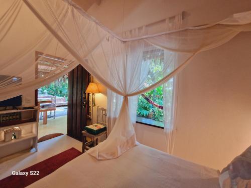a bedroom with a canopy bed with a window at Mini Casa com Jacuzzi e Piscina in Trancoso