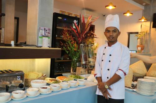 a chef standing in front of a table with food at Kampot Sweet Boutique in Kampot