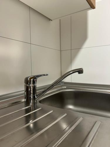 a stainless steel kitchen sink with a faucet at Moderne Service Apartment / Ferienwohnung in Recklinghausen