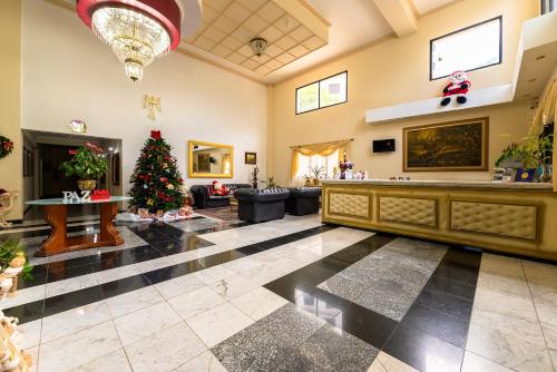 a lobby with a christmas tree in the middle at Rovi Plaza Hotel in Serra Negra