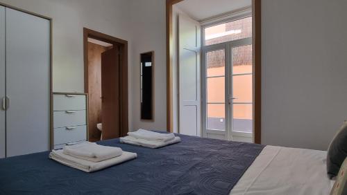 a bedroom with a bed with two towels on it at Lightoasis Oeiras 5 in Oeiras