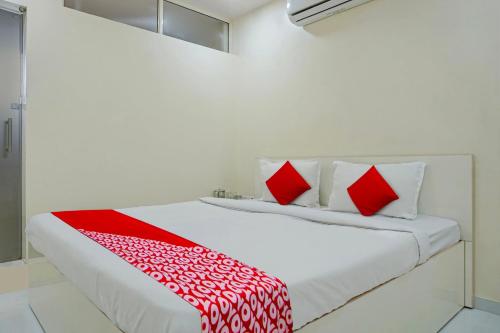 a bedroom with a bed with red and white pillows at Flagship 81482B Happy Homely Stay in Pune