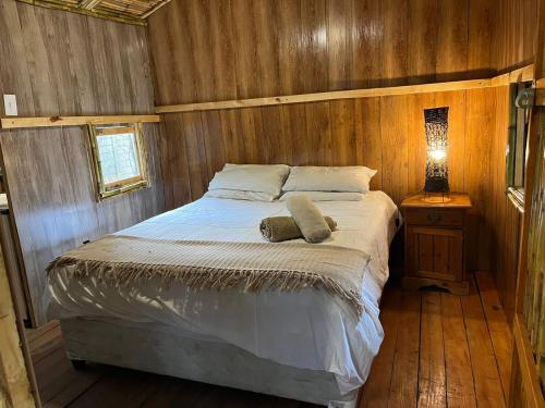 1 dormitorio con 1 cama en una habitación de madera en Sandton Safari Camp, en Johannesburgo