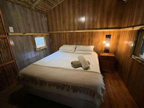ein Schlafzimmer mit einem Bett in einem Holzzimmer in der Unterkunft Sandton Safari Camp in Johannesburg