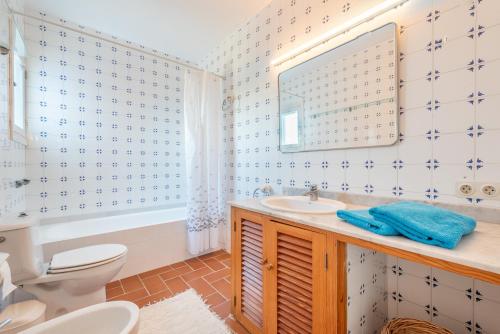 y baño con aseo, lavabo y espejo. en Casa Barca by Mallorca House Rent, en Cala Murada