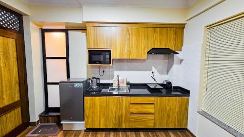 eine Küche mit einer Spüle und einem Kühlschrank in der Unterkunft Badri Homes in Pātan