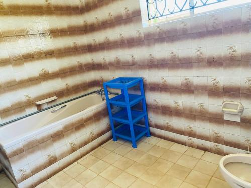 a bathroom with a blue shelf next to a bath tub at Lisa place milimani in Kitale