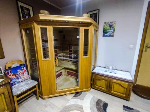a wooden cabinet with a glass door in a room at Apartman Magic Sauna,Jakuzzi,Kino in Livno