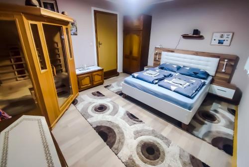 a bedroom with a bed with blue pillows on it at Apartman Magic Sauna,Jakuzzi,Kino in Livno