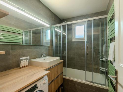 une salle de bain avec un lavabo et une douche en verre dans l'établissement Appartement 3* à 5 min du centre de Morzine, balcon, 2 chambres, parking, service inclus - FR-1-754-36, à Morzine