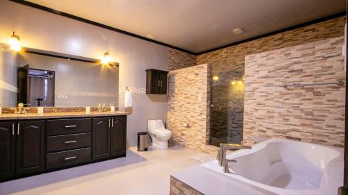 ein Badezimmer mit einer großen Badewanne und einem WC in der Unterkunft Chachagua Suites & Villas in Fortuna