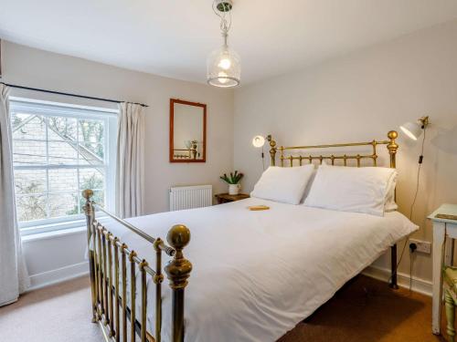 um quarto com uma cama com lençóis brancos e uma janela em 2 Bed in Bath 81298 em Wingfield