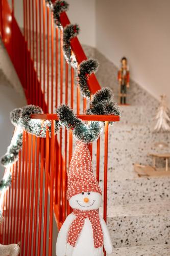 un pupazzo di neve su una scala con decorazioni natalizie di 26 Bricks Suites a Oradea